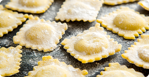 Ravioli fraîches disposées sur un plan de travail, saupoudrées de farine